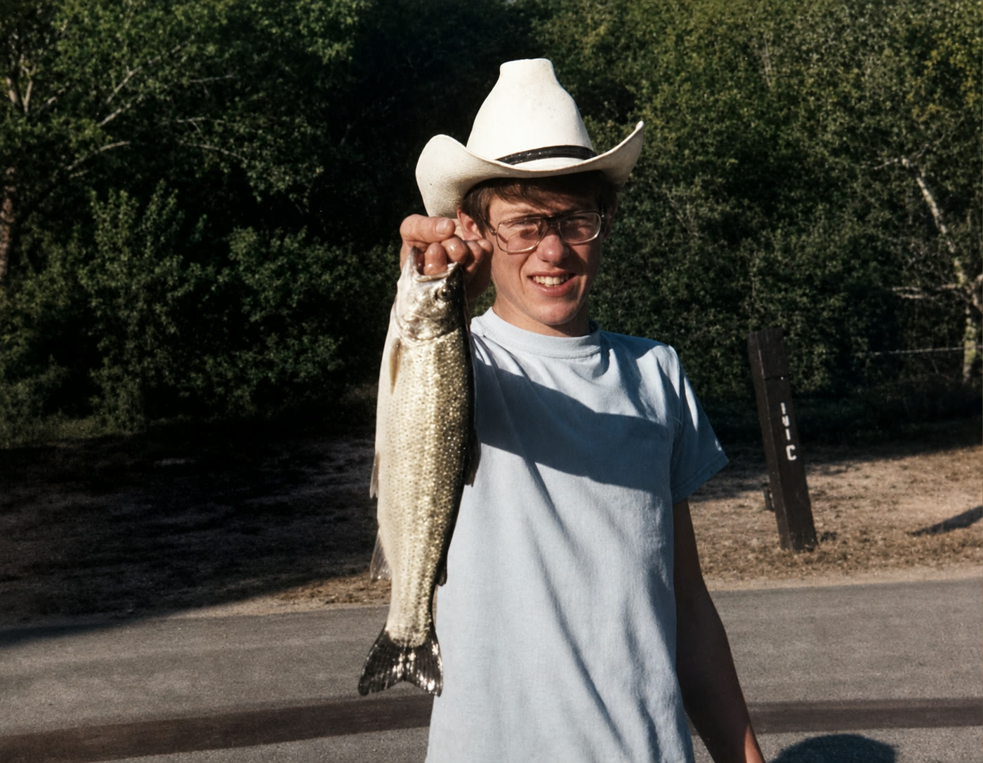 A young Donnie Ho holding a fish outdoors
